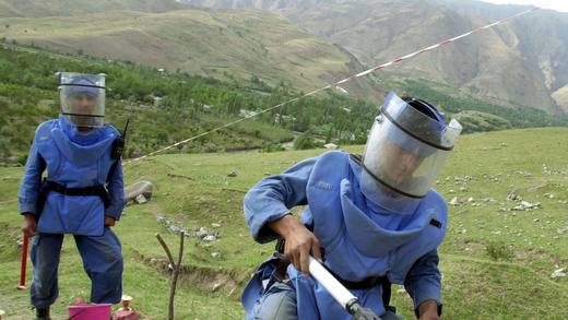 Déminage manuel en zone montagneuse par des opérateurs en tenue de protection